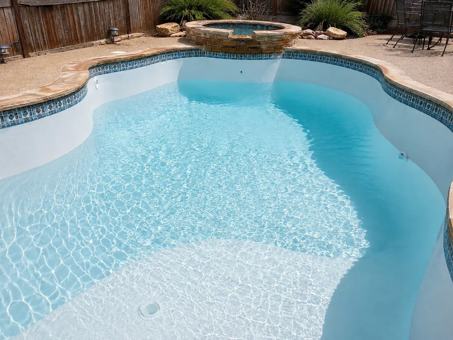 After: the same pool replastered with a fresh white finish and clear blue water
