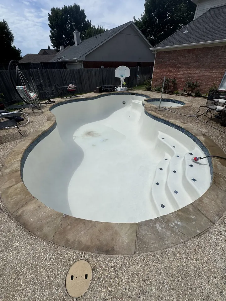 Freeform pool with new white plaster finish in an Arlington, TX backyard