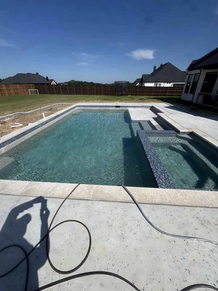 Rectangular pool and raised spa refilled after replastering in Flower Mound, TX