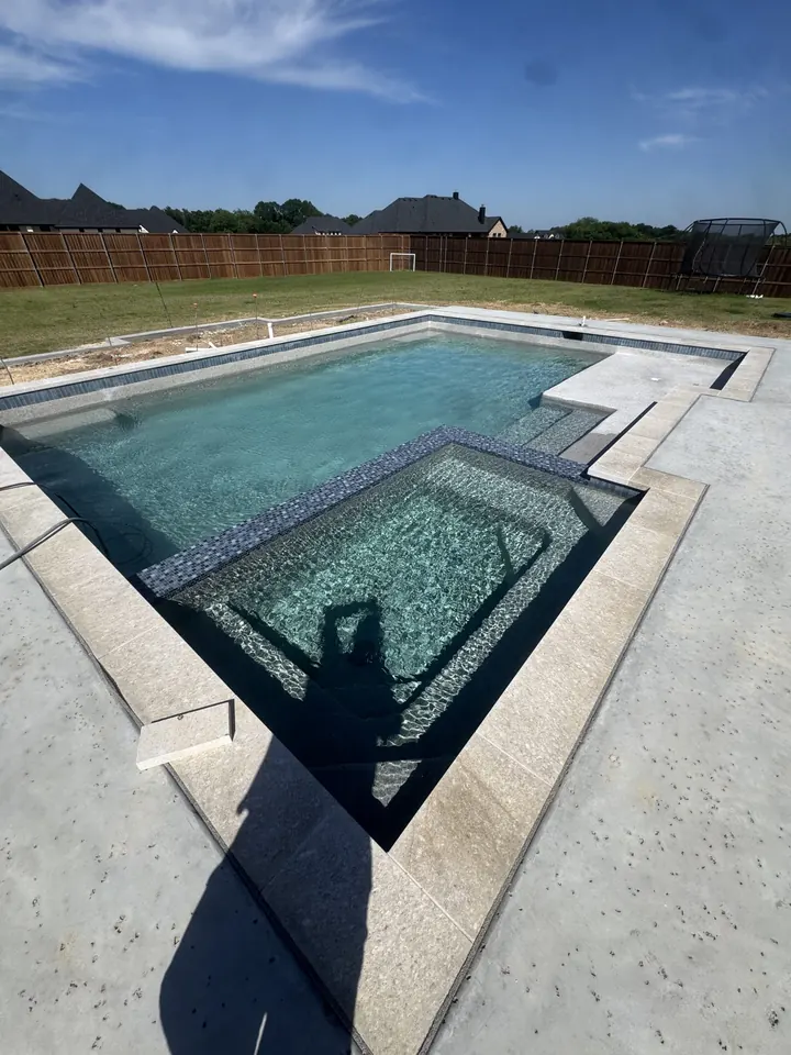 Pool and attached spa filling with water after replastering in Flower Mound, TX