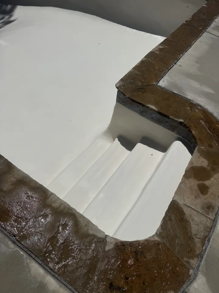 Close-up of new pool steps, white plaster and stone coping in Keller, TX