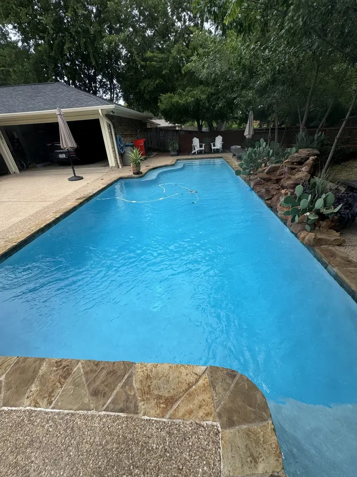 Rectangular pool with fresh replaster and clear blue water in a Lewisville, TX backyard